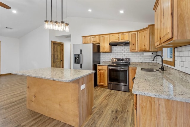 kitchen with a center island, sink, vaulted ceiling, appliances with stainless steel finishes, and light hardwood / wood-style floors