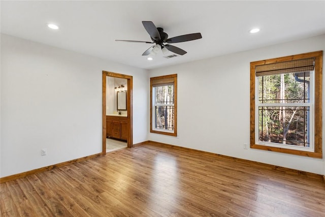 spare room with hardwood / wood-style flooring, ceiling fan, and sink