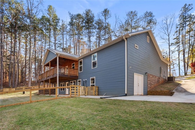 rear view of property with a patio, a yard, a deck, and cooling unit