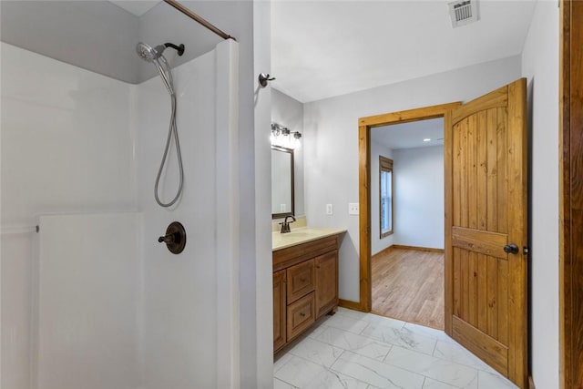 bathroom with vanity, hardwood / wood-style flooring, and walk in shower