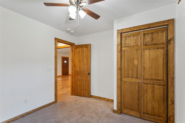 unfurnished bedroom with ceiling fan, a closet, and light colored carpet