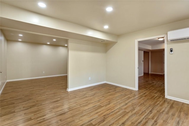 basement featuring a wall mounted air conditioner and wood-type flooring