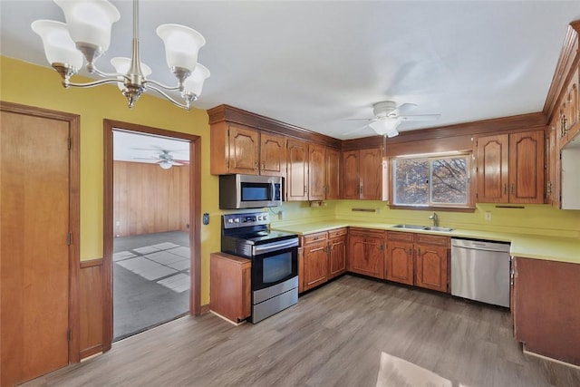 kitchen featuring sink, hardwood / wood-style floors, pendant lighting, and appliances with stainless steel finishes