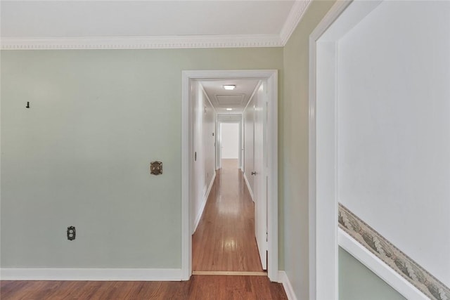 hallway with wood-type flooring and ornamental molding