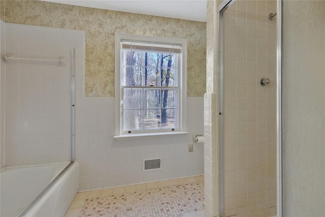 bathroom with tile patterned floors and bath / shower combo with glass door