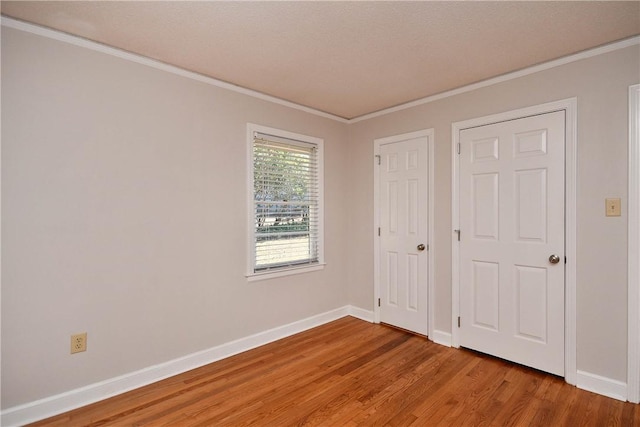 unfurnished bedroom featuring ornamental molding, a textured ceiling, and hardwood / wood-style flooring