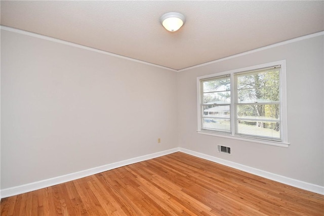 unfurnished room featuring wood-type flooring, a textured ceiling, and crown molding