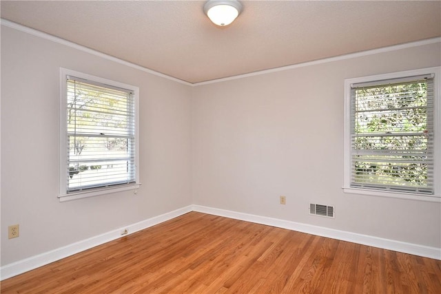 spare room with crown molding, hardwood / wood-style floors, and a textured ceiling