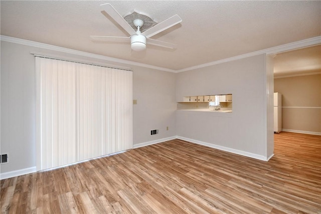 spare room featuring ceiling fan, light hardwood / wood-style floors, ornamental molding, and a textured ceiling