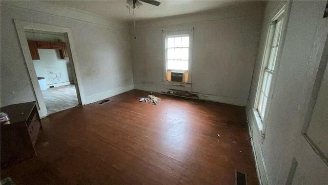 empty room featuring ceiling fan, cooling unit, and dark hardwood / wood-style floors