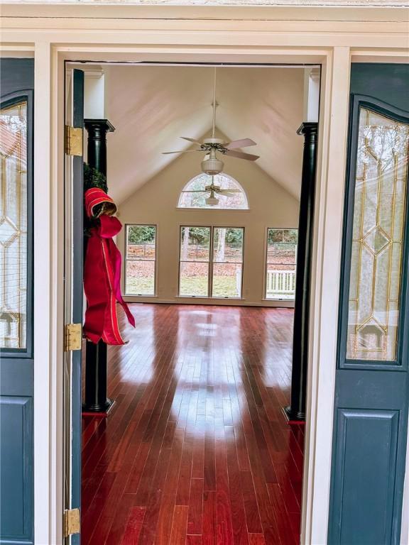 interior space featuring vaulted ceiling, ceiling fan, and dark wood-type flooring