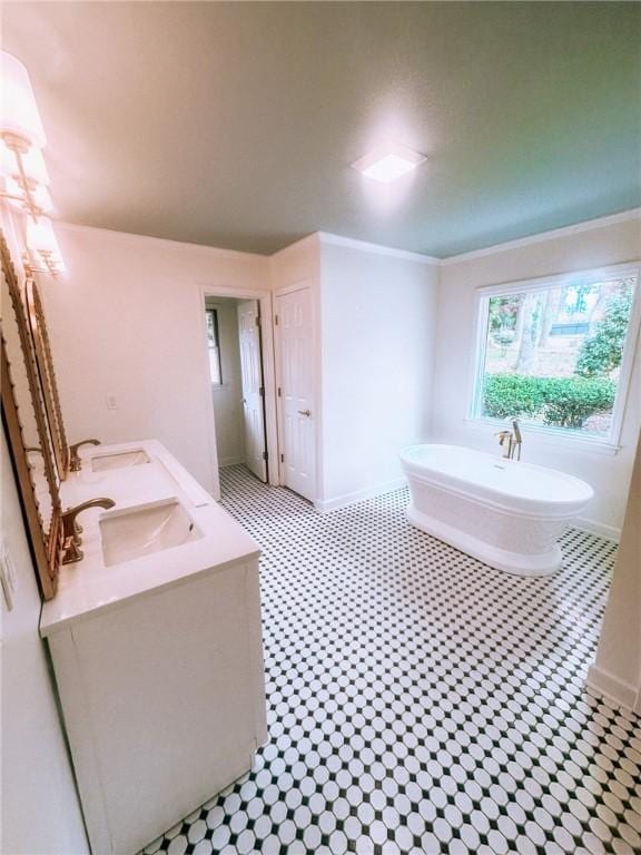 bathroom with vanity, a tub to relax in, and crown molding