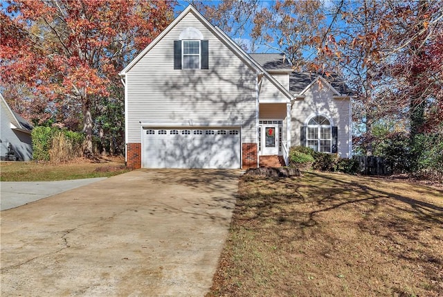 view of property with a garage and a front lawn