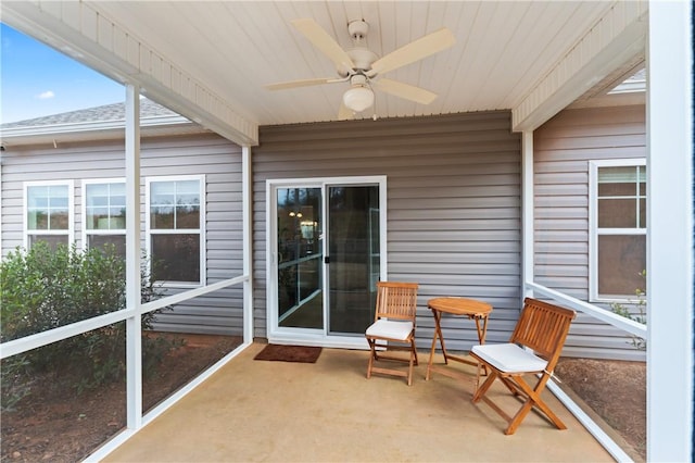 sunroom / solarium with beam ceiling, a wealth of natural light, and ceiling fan