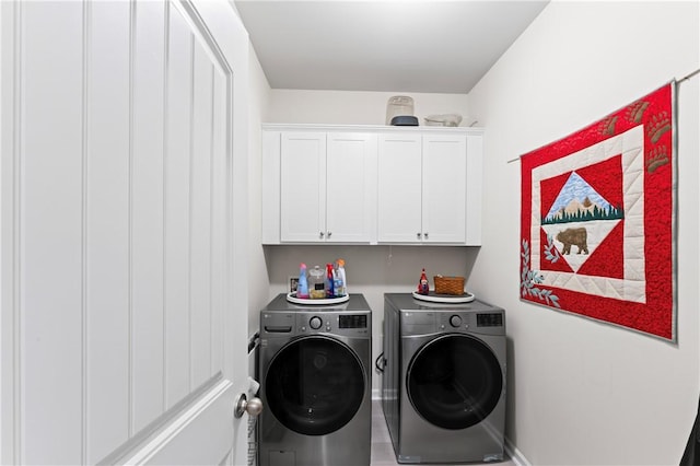 clothes washing area with washer and dryer and cabinets