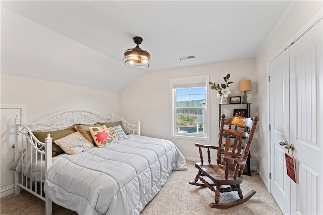 carpeted bedroom with a closet and lofted ceiling