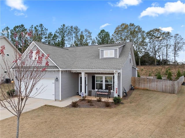 view of front of house featuring covered porch, a front yard, and a garage