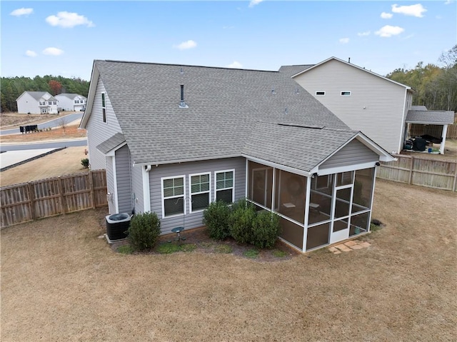 rear view of house with a yard, cooling unit, and a sunroom