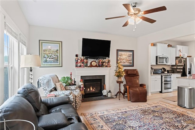 living room featuring light wood-type flooring and ceiling fan