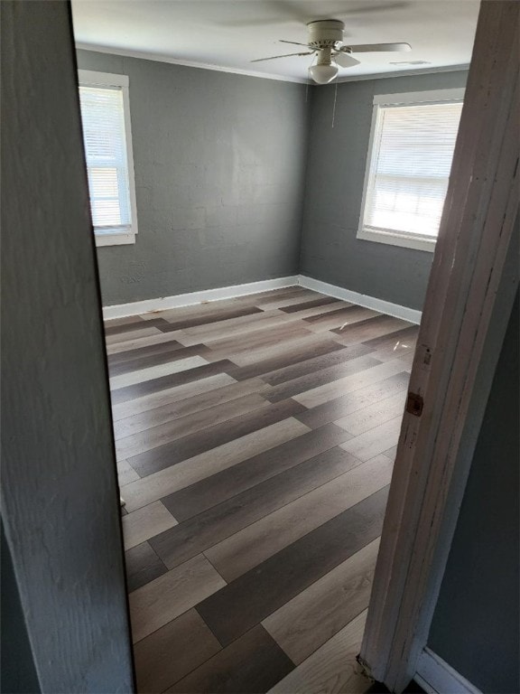 spare room featuring wood-type flooring, ceiling fan, and a healthy amount of sunlight