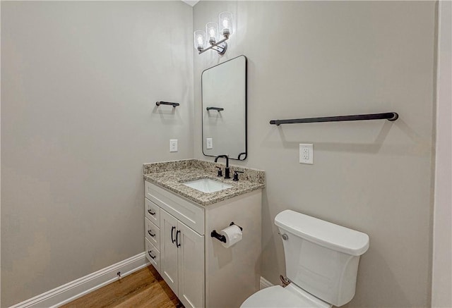 bathroom with wood-type flooring, vanity, and toilet