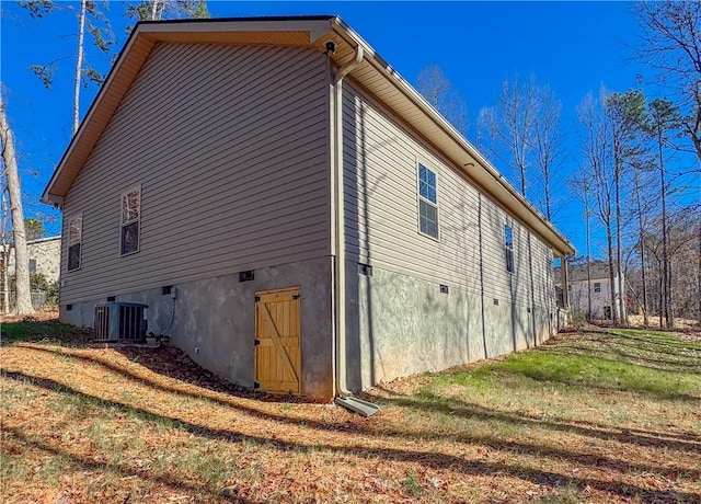 view of property exterior with a lawn and central AC