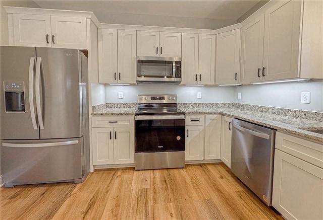 kitchen featuring white cabinets, appliances with stainless steel finishes, and light wood-type flooring