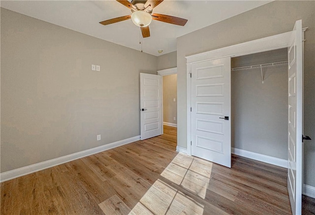 unfurnished bedroom with wood-type flooring, a closet, and ceiling fan