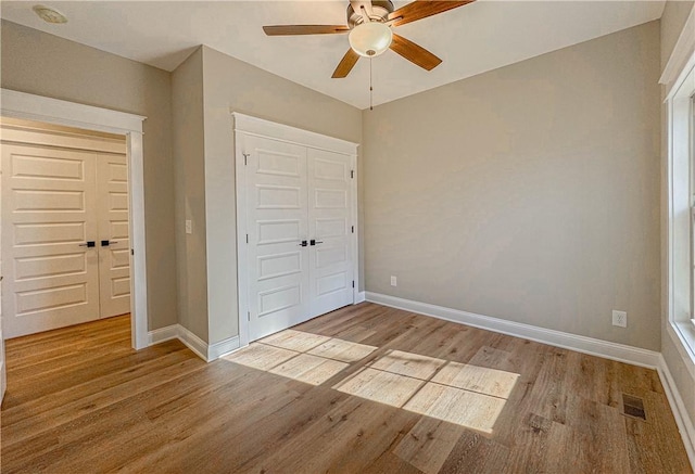 unfurnished bedroom featuring ceiling fan, light hardwood / wood-style floors, and a closet