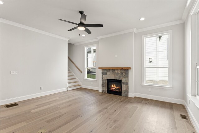 unfurnished living room with ceiling fan, ornamental molding, a fireplace, and light hardwood / wood-style flooring