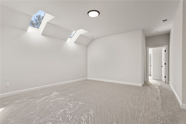 unfurnished room featuring carpet flooring and a skylight