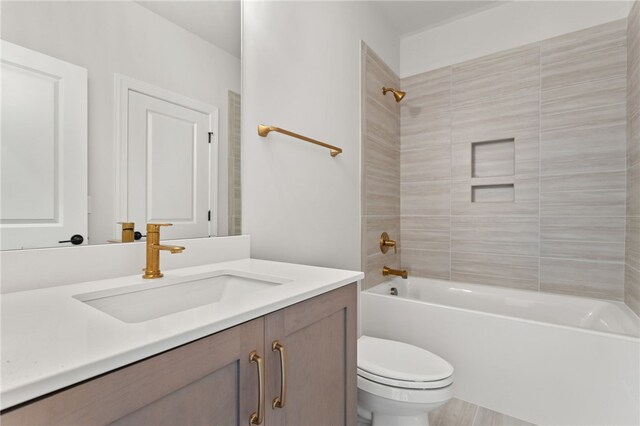 full bathroom featuring toilet, vanity, and tiled shower / bath