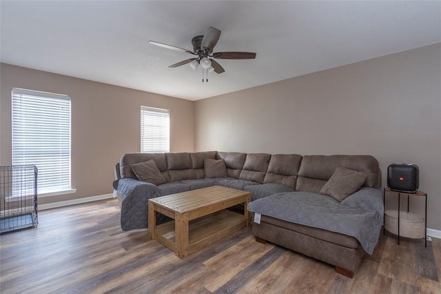 living room featuring ceiling fan and dark wood-type flooring