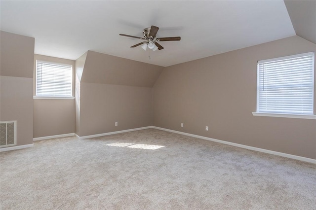 additional living space with light colored carpet, ceiling fan, and lofted ceiling