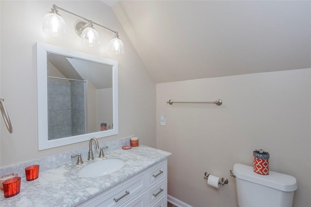 bathroom with vanity, toilet, and lofted ceiling