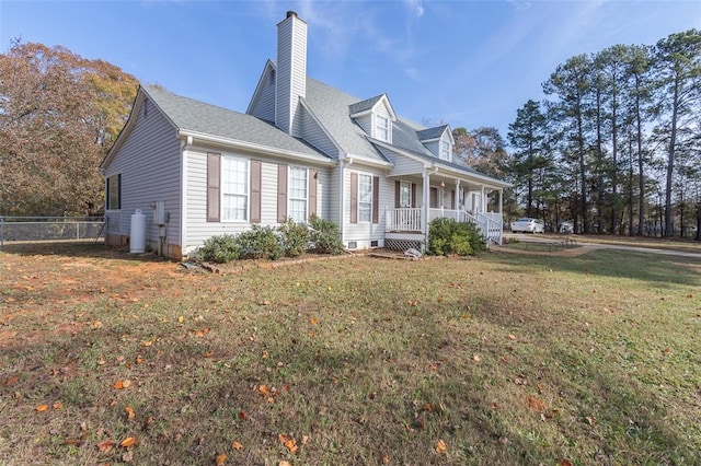 view of side of property featuring a yard and covered porch