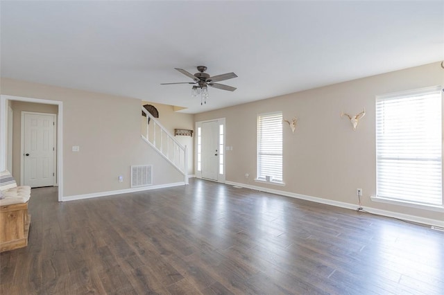 unfurnished living room with dark wood-type flooring and a wealth of natural light