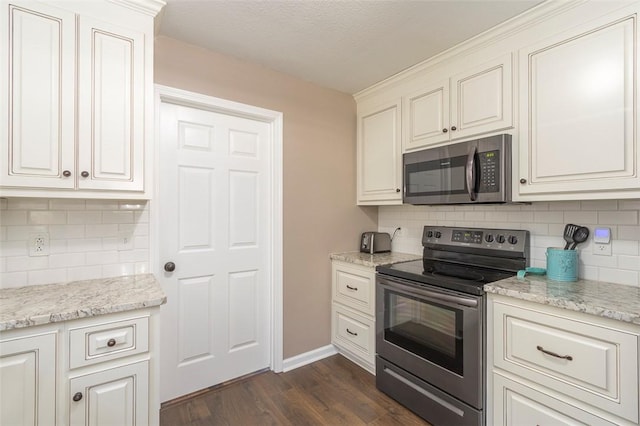 kitchen with stainless steel appliances, tasteful backsplash, light stone counters, dark hardwood / wood-style floors, and white cabinets