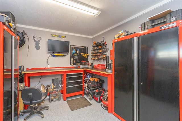 interior space with a workshop area, black fridge, and crown molding