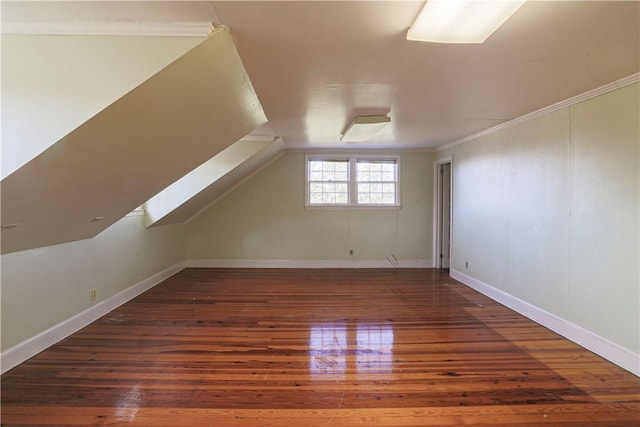 bonus room featuring lofted ceiling, dark wood-style flooring, and baseboards