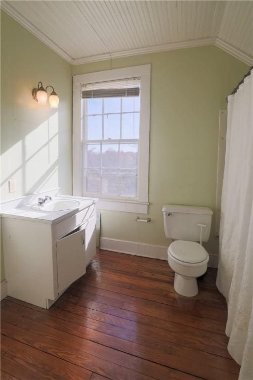 bathroom featuring toilet, ornamental molding, wood finished floors, and vanity