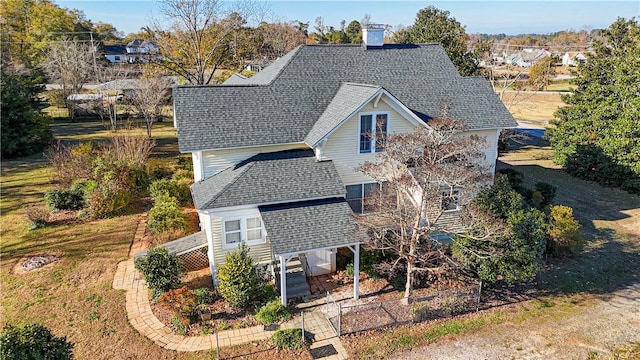 exterior space featuring a shingled roof and a chimney