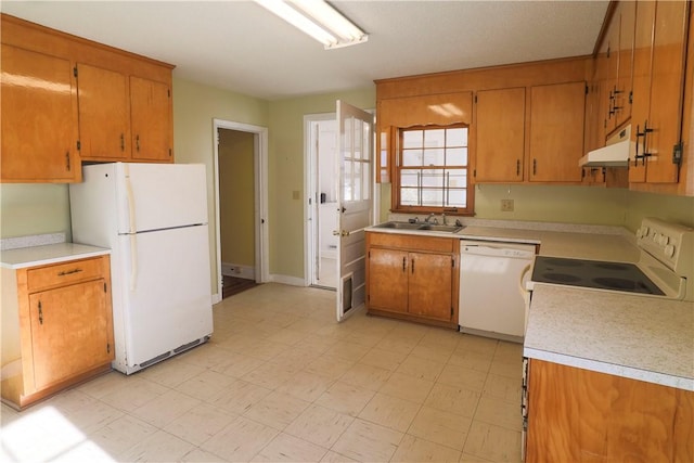 kitchen featuring white appliances, light countertops, and brown cabinetry