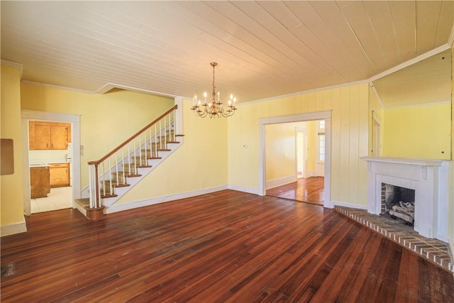 unfurnished living room with baseboards, ornamental molding, wood finished floors, stairs, and a brick fireplace