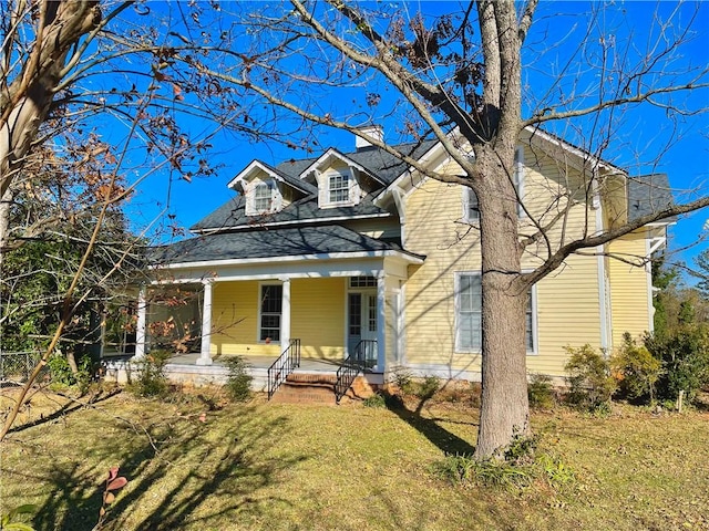 view of front of house with a front yard and covered porch