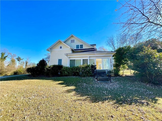 back of property featuring a lawn