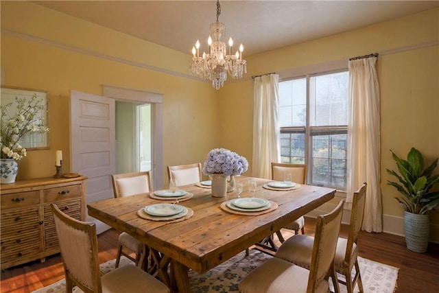 dining area with a chandelier, dark wood-style flooring, and baseboards