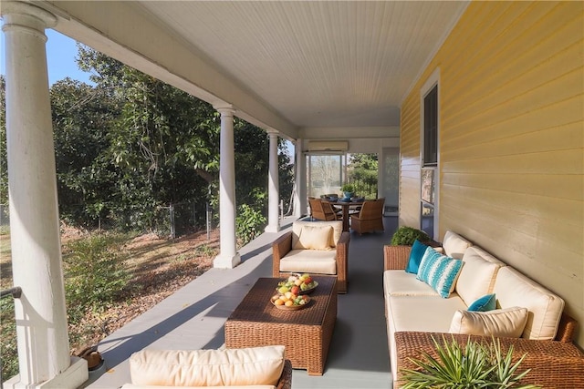 view of patio / terrace with outdoor dining space, a wall unit AC, and an outdoor living space