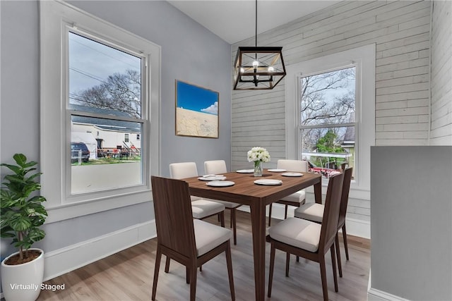 dining area with a healthy amount of sunlight, baseboards, a chandelier, and wood finished floors