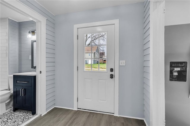 entryway with baseboards and wood finished floors